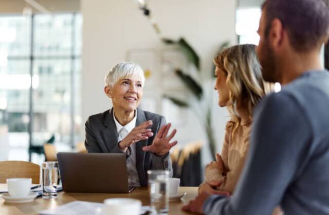 https-media-gettyimages-com-id-1408583107-photo-happy-female-insurance-agent-talking-to-a-couple-on-a-meeting-in-the-office